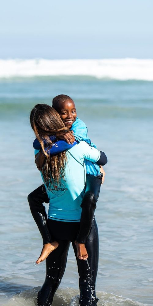 Een mooi moment met een vrijwilliger en kind tijdens surfen