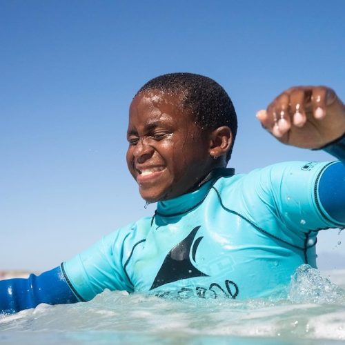Leren surfen met de kinderen tijdens het Jeugd Educatie vrijwilligerswerk programma